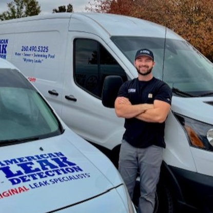 Two vans, technician leaning against one